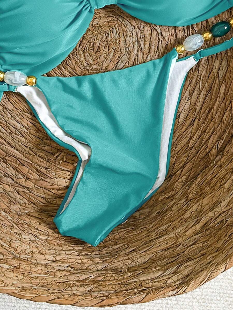 Women's green halter neck bikini set featuring color-block beaded shoulder straps, back tie detail, and high cut bottoms.