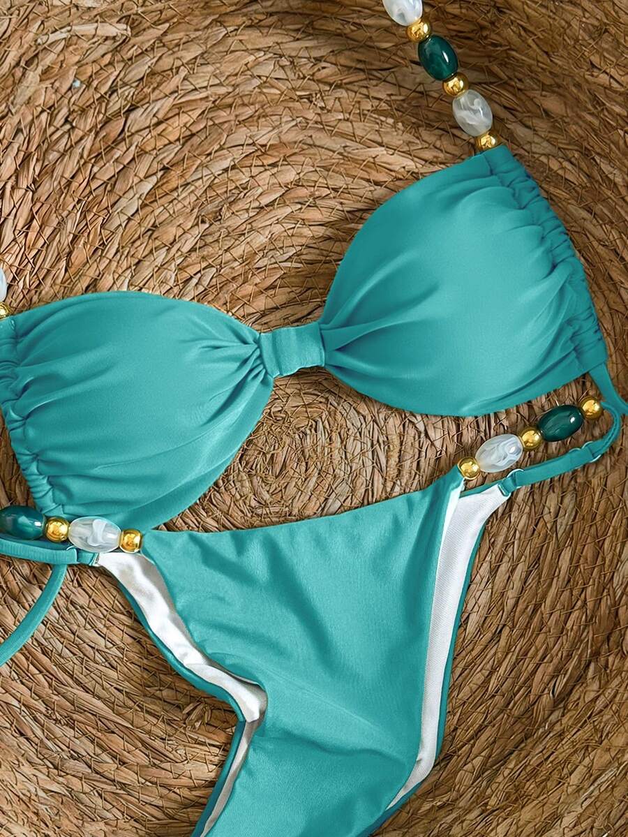 Women's green halter neck bikini set featuring color-block beaded shoulder straps, back tie detail, and high cut bottoms.