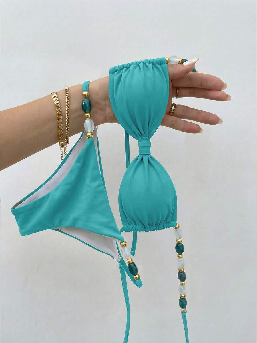 Women's green halter neck bikini set featuring color-block beaded shoulder straps, back tie detail, and high cut bottoms.