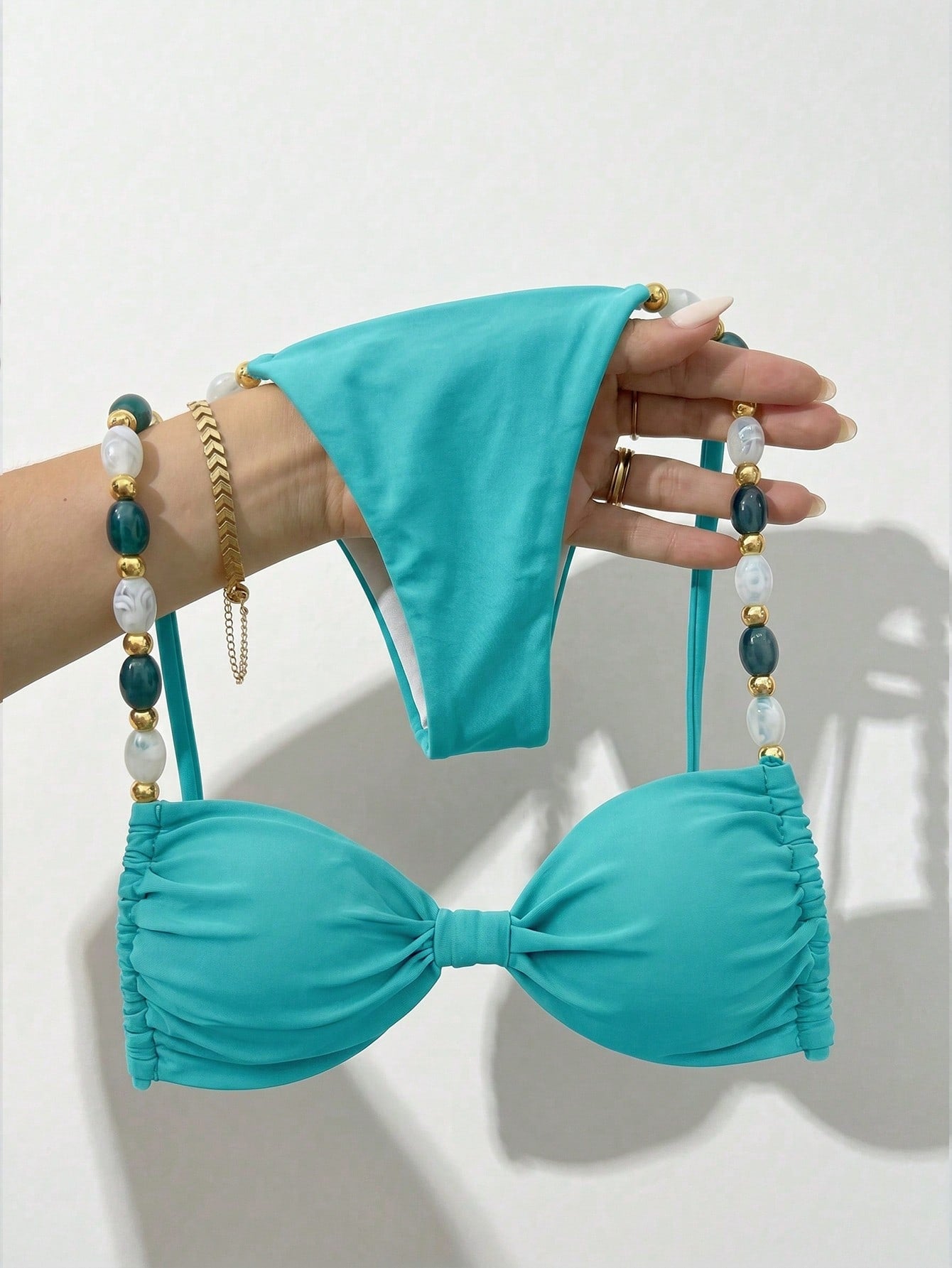 Women's green halter neck bikini set featuring color-block beaded shoulder straps, back tie detail, and high cut bottoms.