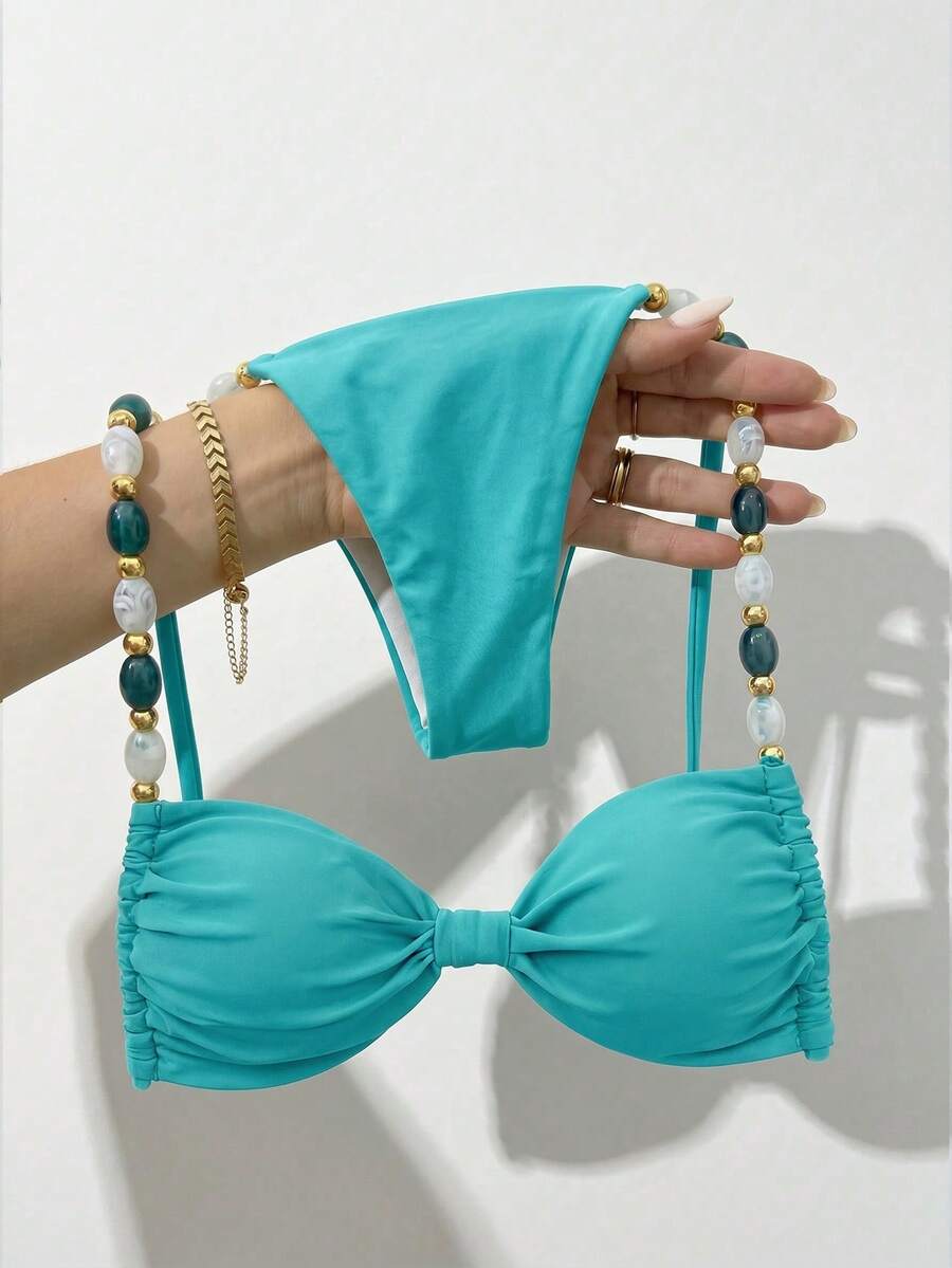 Women's green halter neck bikini set featuring color-block beaded shoulder straps, back tie detail, and high cut bottoms.