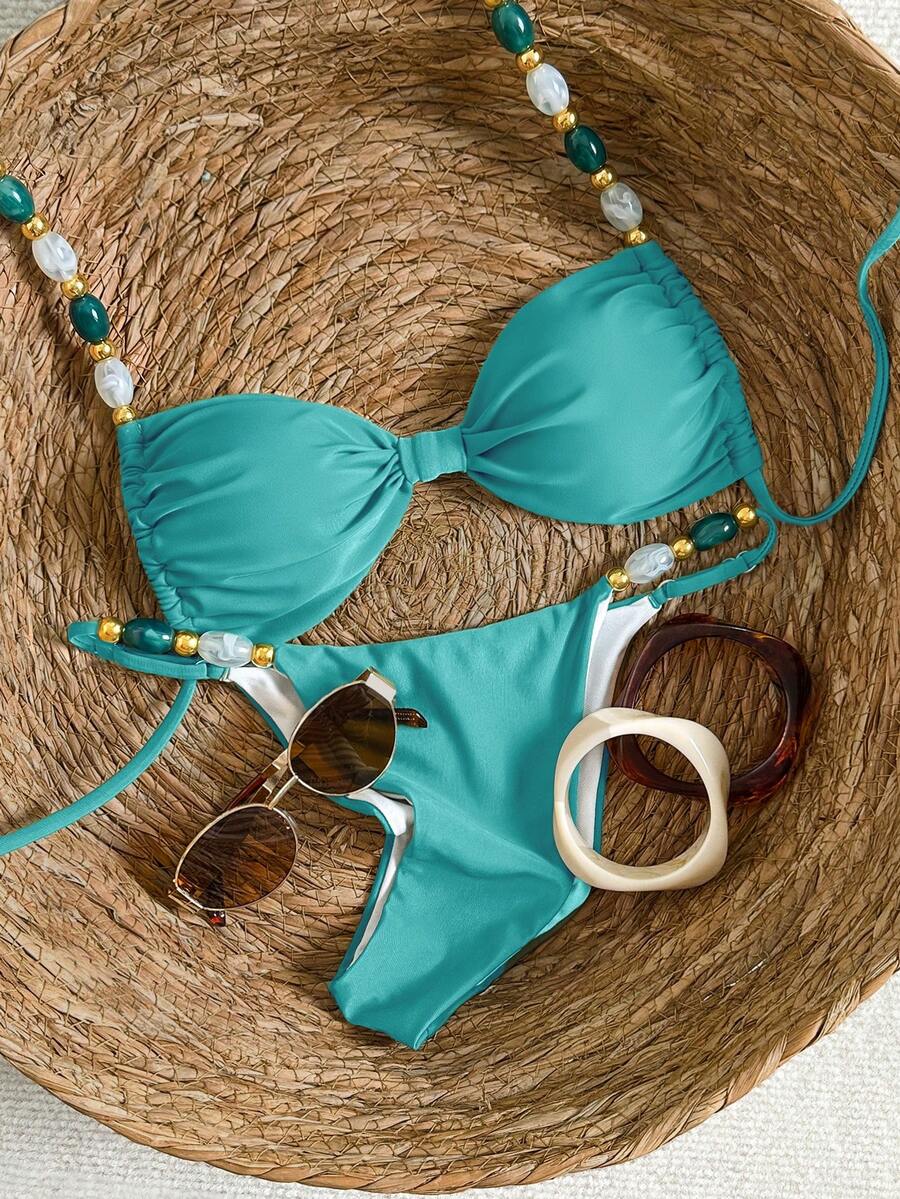 Women's green halter neck bikini set featuring color-block beaded shoulder straps, back tie detail, and high cut bottoms.
