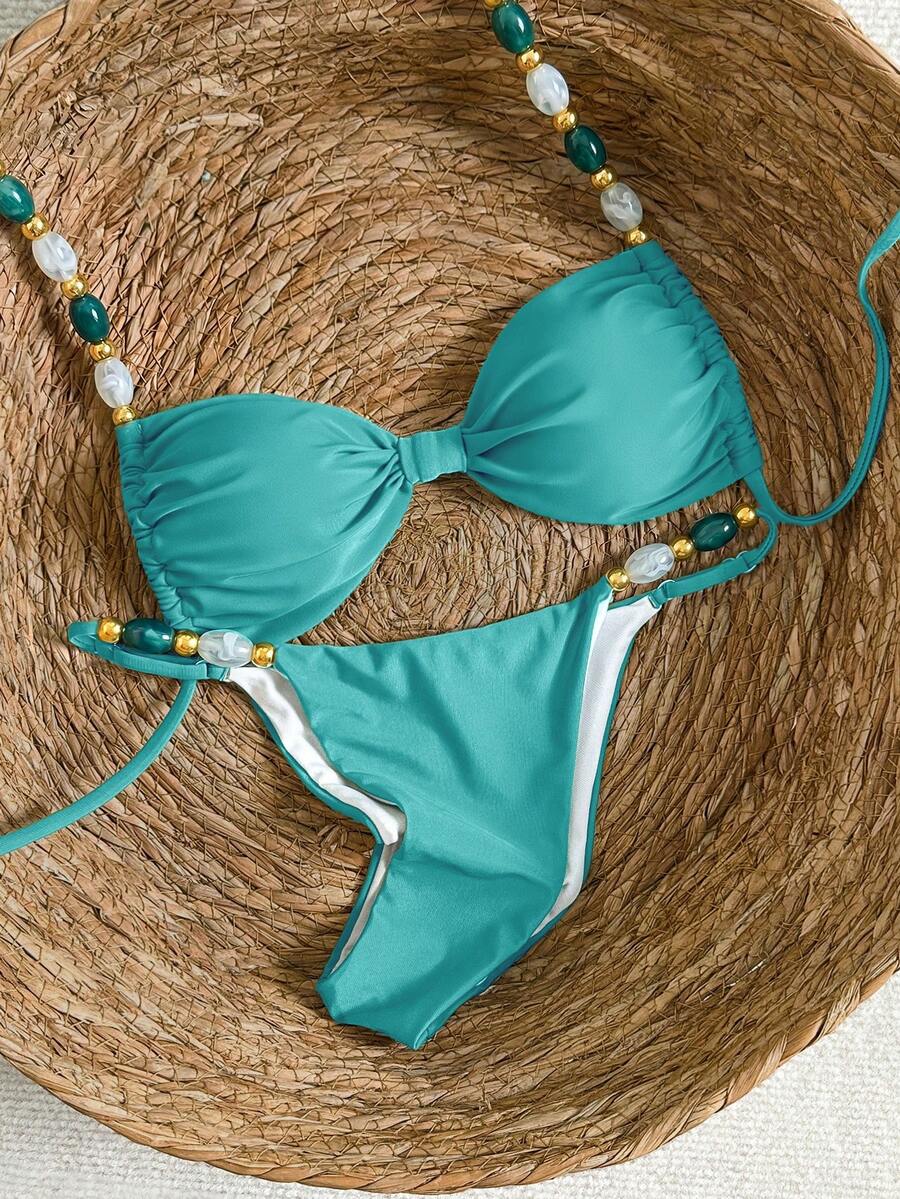 Women's green halter neck bikini set featuring color-block beaded shoulder straps, back tie detail, and high cut bottoms.