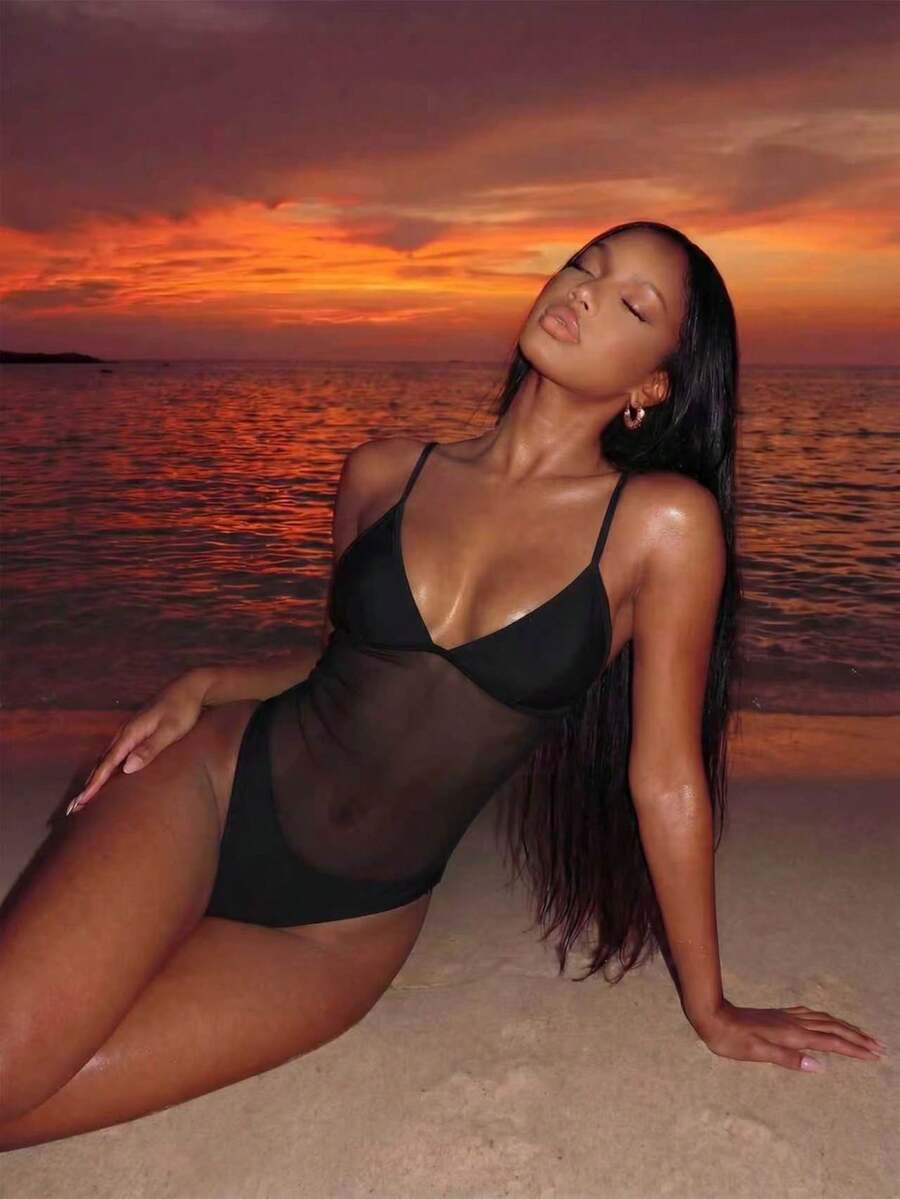 Women's black one-piece swimsuit with mesh patchwork detailing, spaghetti straps, backless style, and high cut bottom.