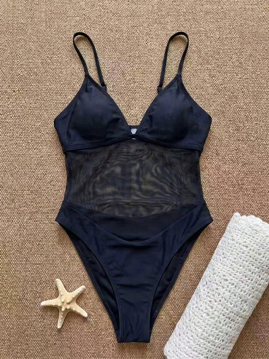 Women's black one-piece swimsuit with mesh patchwork detailing, spaghetti straps, backless style, and high cut bottom.