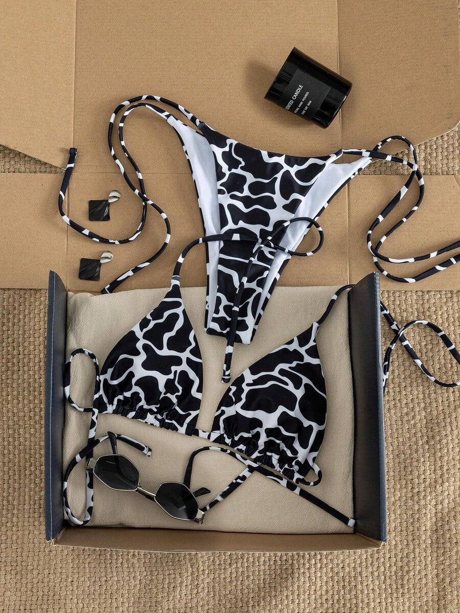Women's two-piece black bikini set showing a halter triangle tie-back top and matching side-tie bikini bottoms.