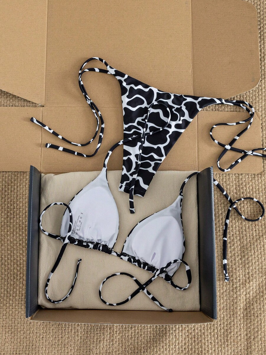 Women's two-piece black bikini set showing a halter triangle tie-back top and matching side-tie bikini bottoms.