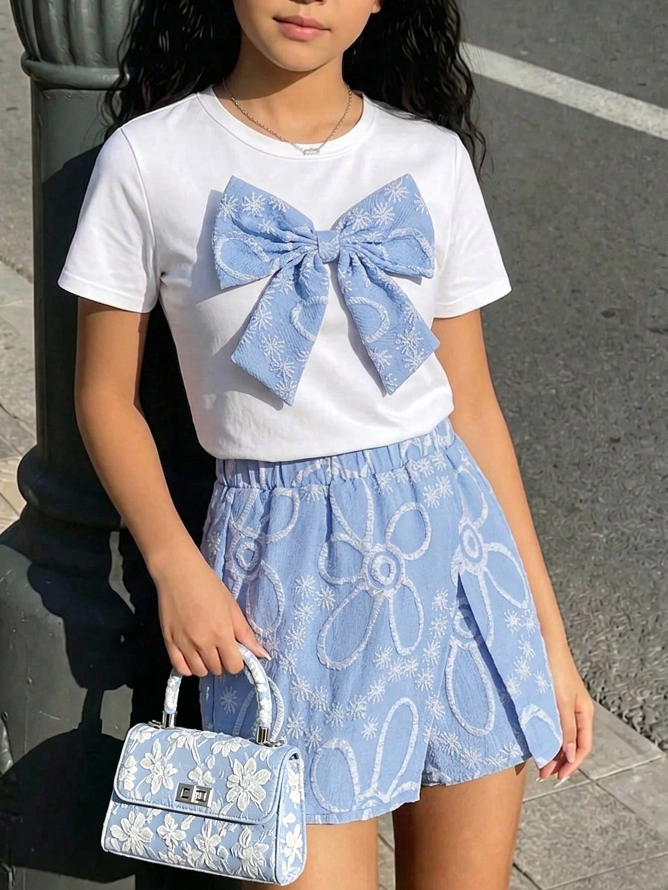 Tween girls 2-piece blue outfit featuring a short sleeve round neck t-shirt with a bow front detail and an asymmetric wrap skort.