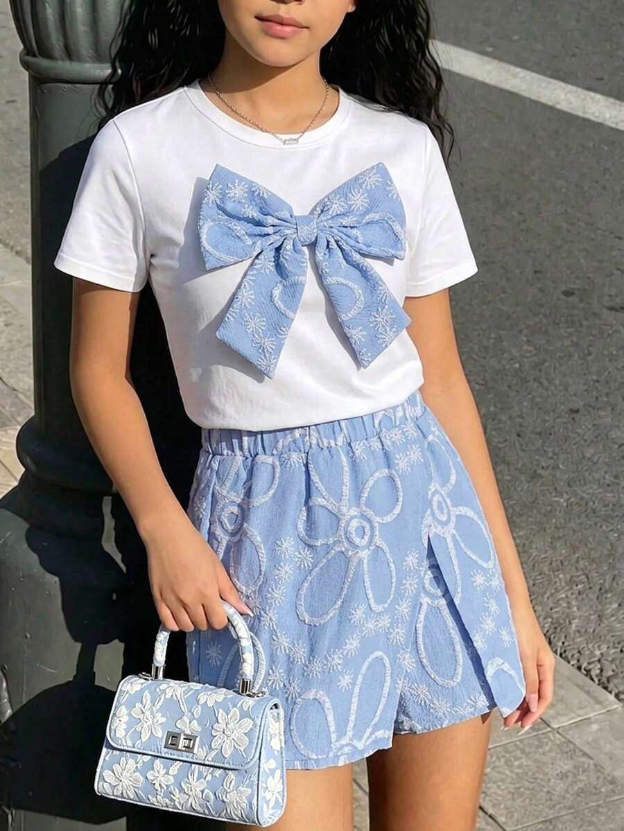 Tween girls 2-piece blue outfit featuring a short sleeve round neck t-shirt with a bow front detail and an asymmetric wrap skort.