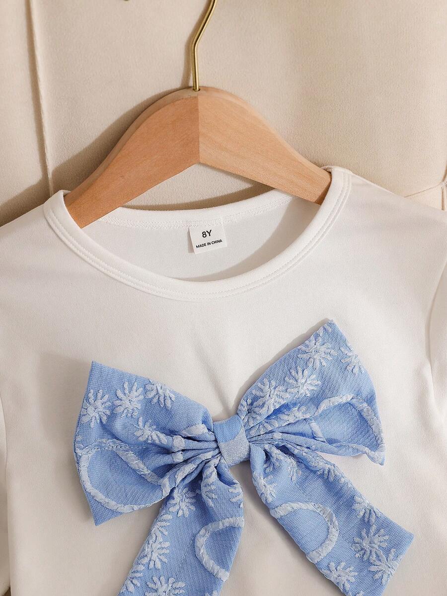 Tween girls 2-piece blue outfit featuring a short sleeve round neck t-shirt with a bow front detail and an asymmetric wrap skort.