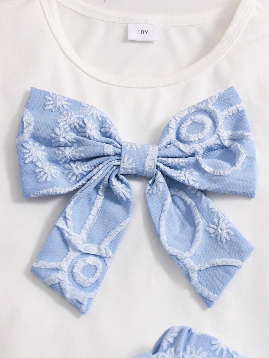 Tween girls 2-piece blue outfit featuring a short sleeve round neck t-shirt with a bow front detail and an asymmetric wrap skort.