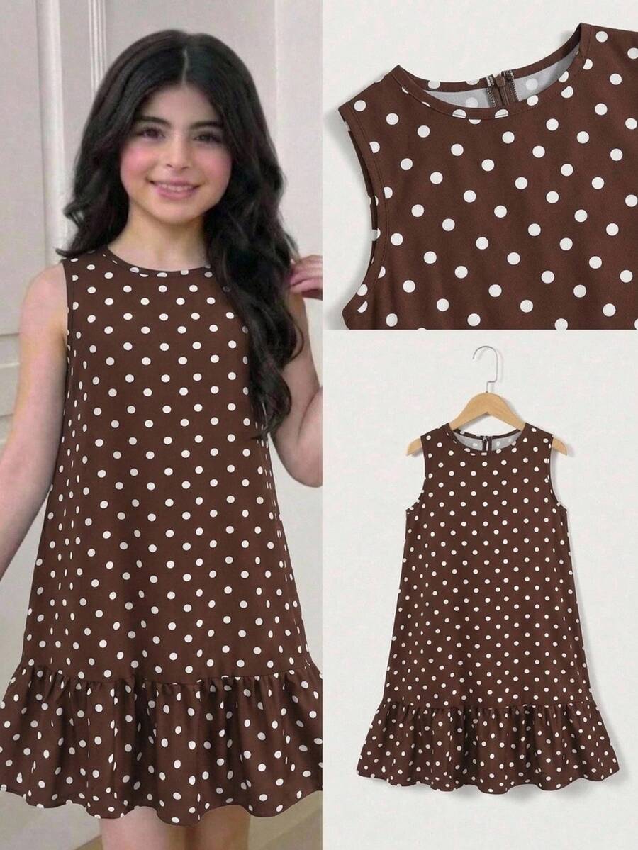Tween girl wearing a sleeveless black tunic dress featuring a round neck, contrast lace details, and a straight hem.
