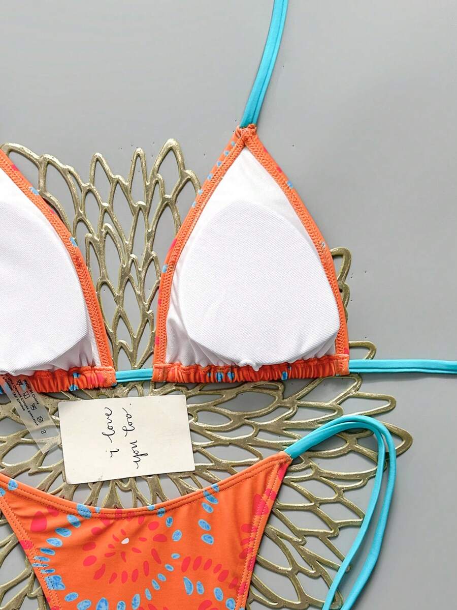 Women's black halter bikini set featuring triangle cups with gold bead decor and tie-back closure