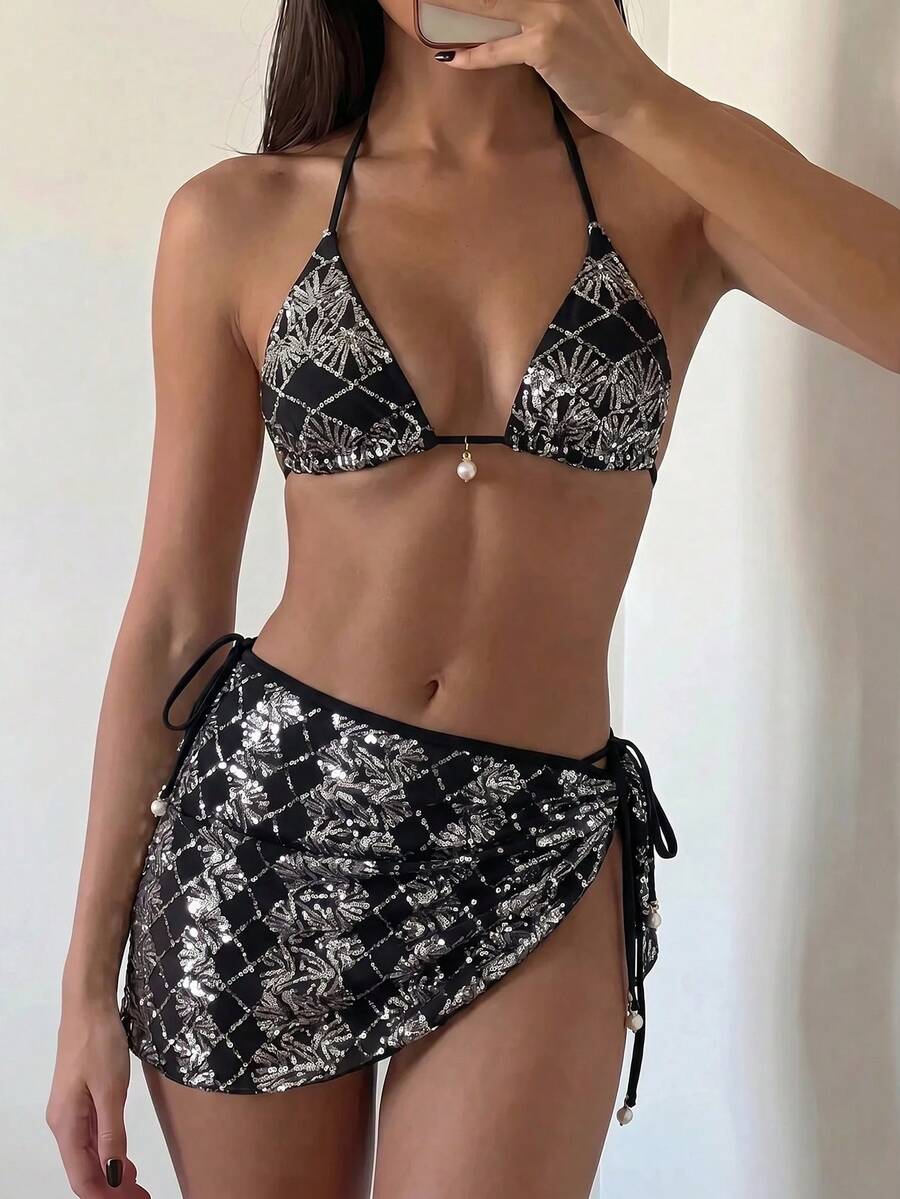 Women's 3-piece blue tropical shell print bikini set featuring a halter bralette top, low-waist tie-side bottom, and a matching sheer mesh cover-up skirt.