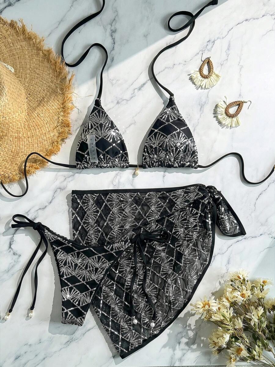 Women's 3-piece blue tropical shell print bikini set featuring a halter bralette top, low-waist tie-side bottom, and a matching sheer mesh cover-up skirt.