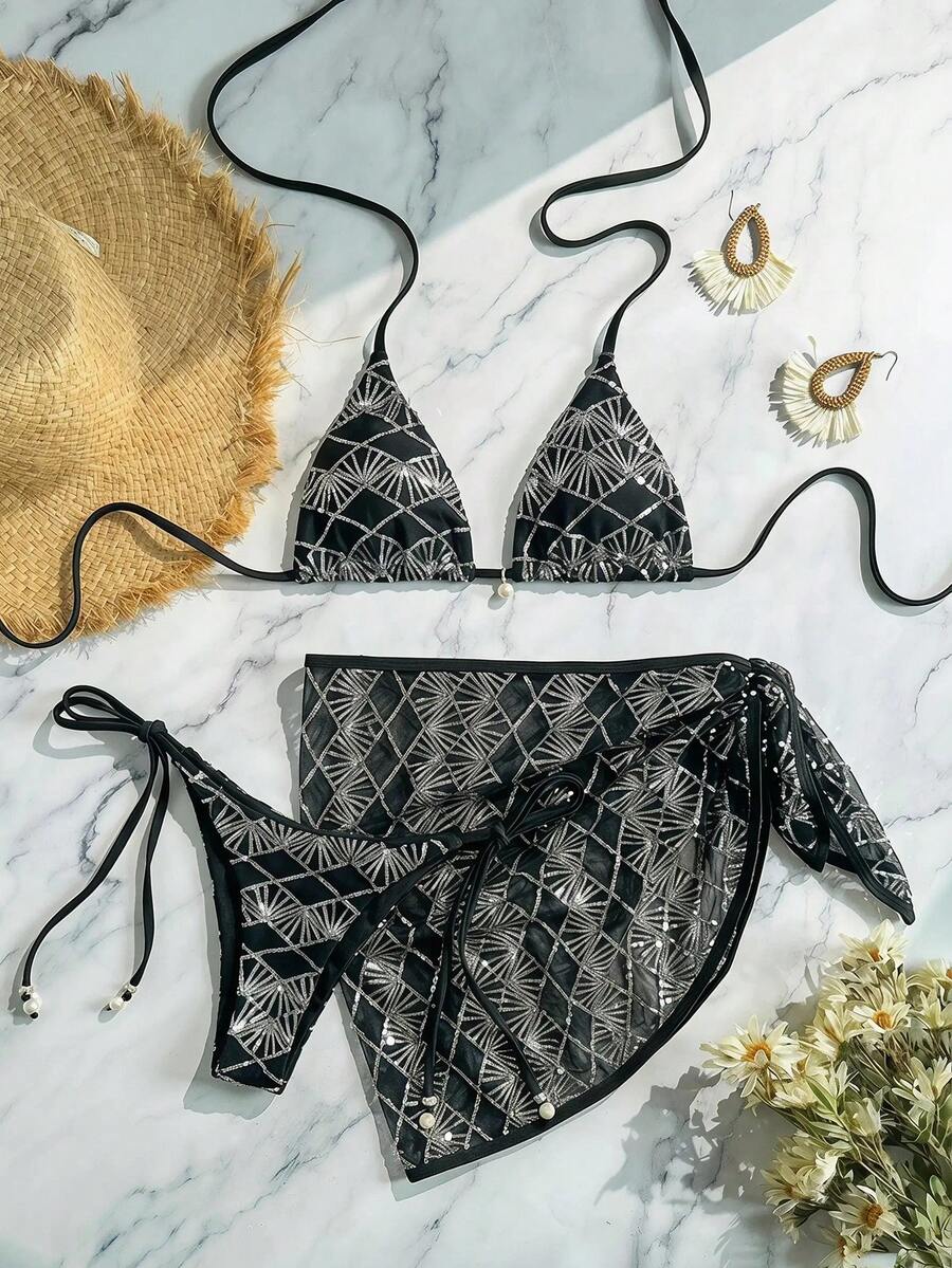 Women's 3-piece blue tropical shell print bikini set featuring a halter bralette top, low-waist tie-side bottom, and a matching sheer mesh cover-up skirt.