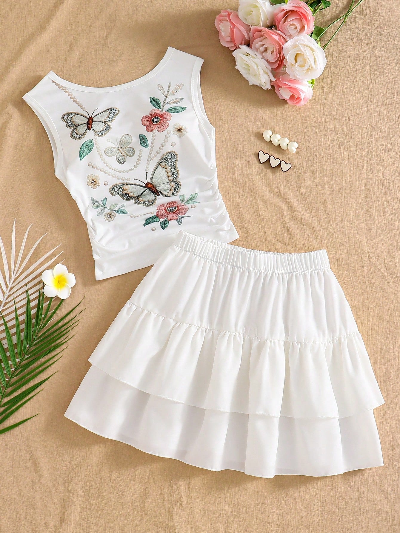 Light blue two-piece outfit set for tween girls with a sleeveless round neck vest top and a tiered ruffle cake skirt featuring a plant pattern.