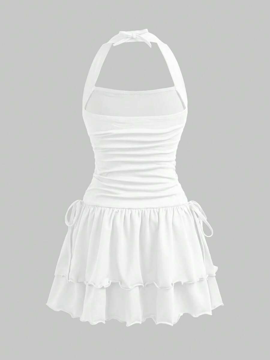Black sleeveless halter polka dot mini dress for tween girls featuring a high waist and flared hem