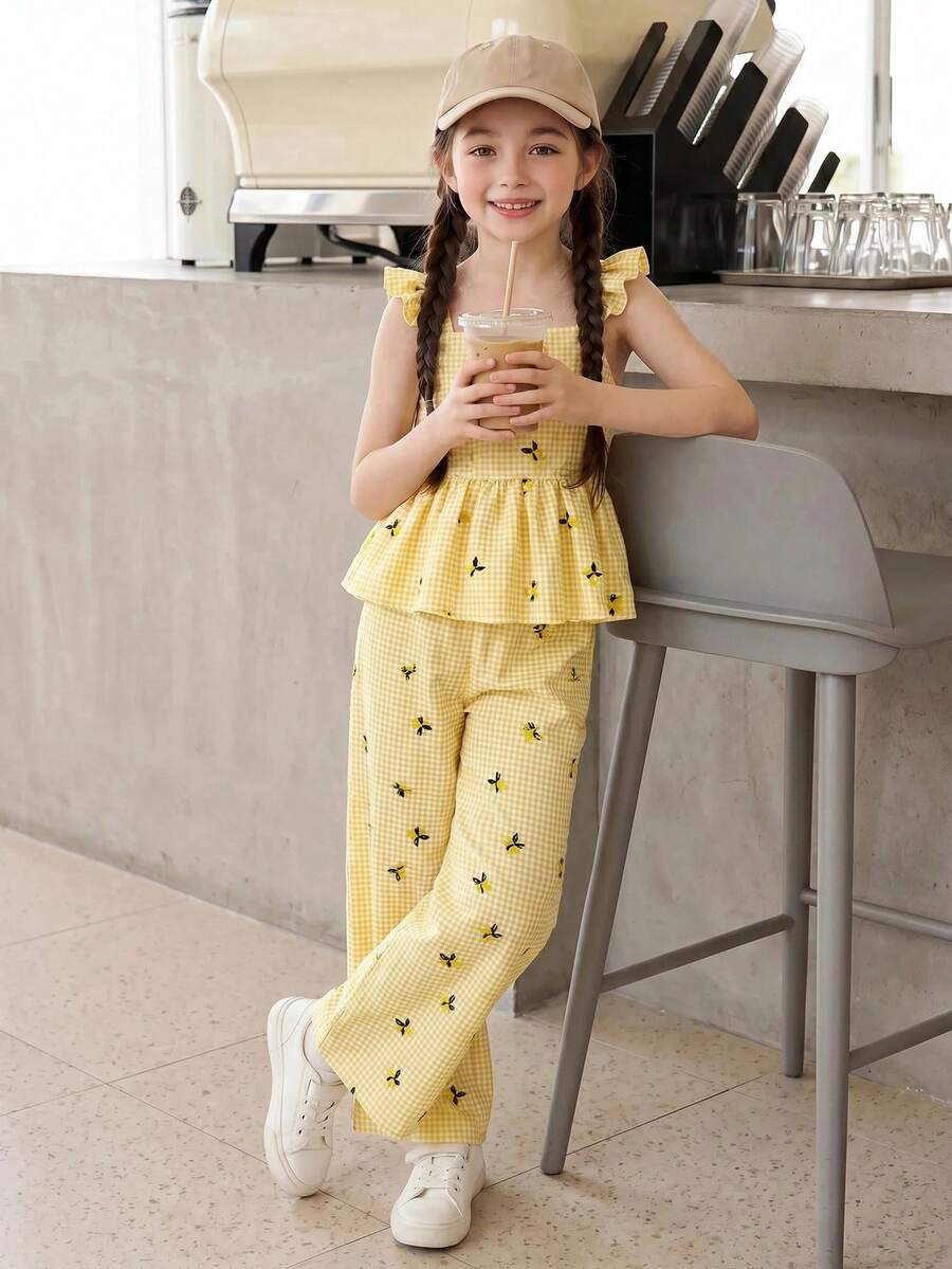 Tween girl wearing an apricot 2-piece outfit set featuring a shirred spaghetti strap short cami top and matching wide-leg long pants.