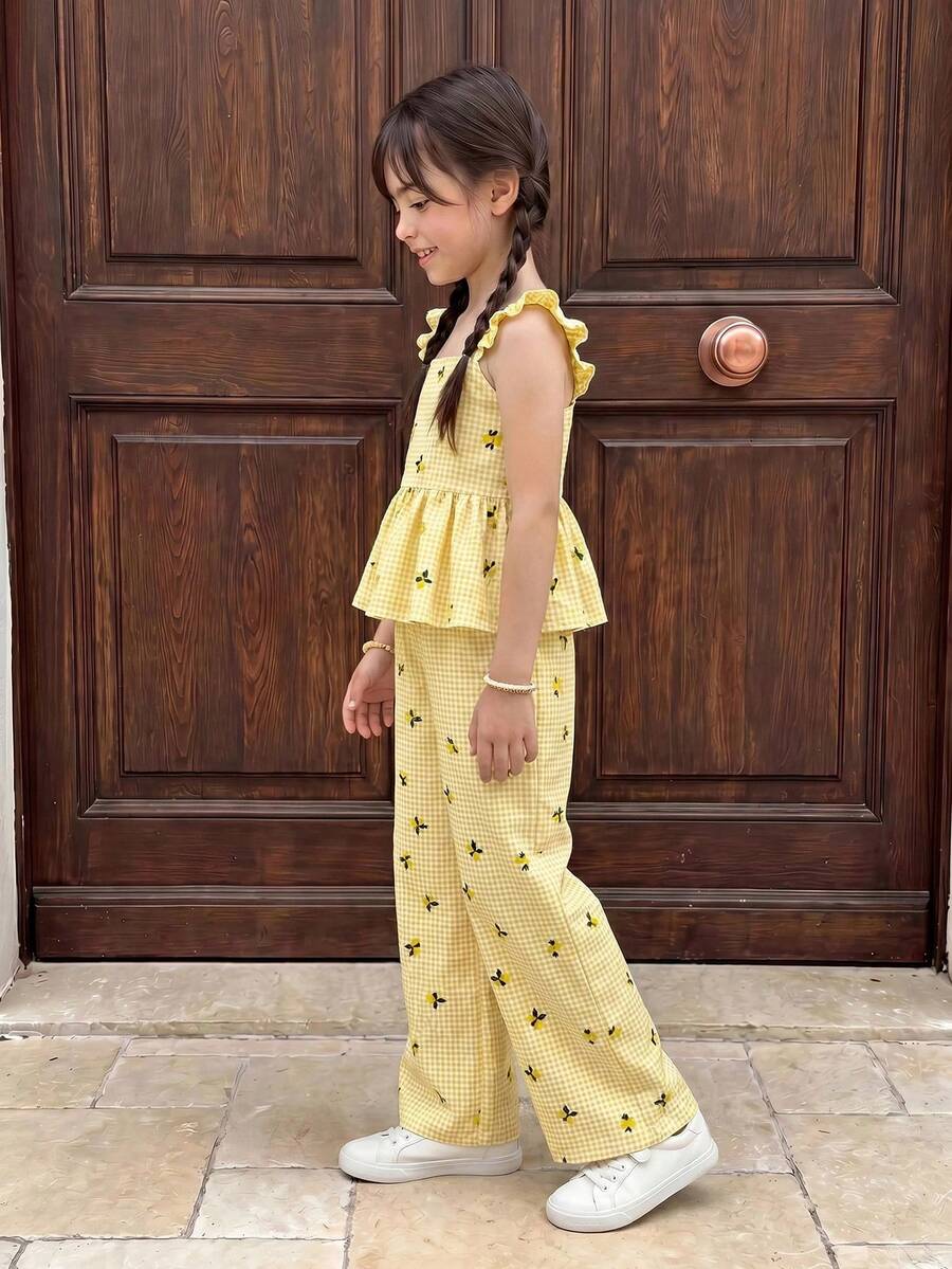Tween girl wearing an apricot 2-piece outfit set featuring a shirred spaghetti strap short cami top and matching wide-leg long pants.