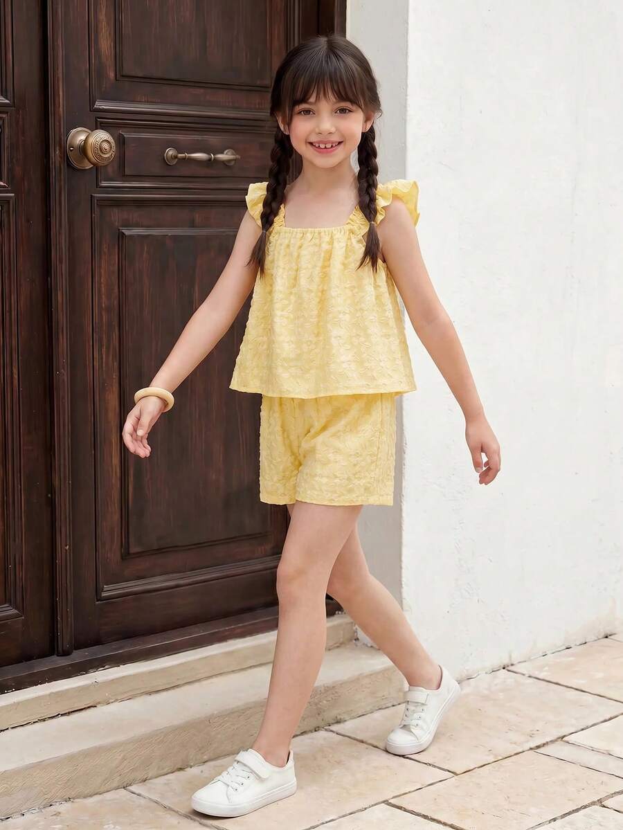 Tween girl wearing a blue and white striped sleeveless top featuring embroidery details and ruffle trim with matching shorts.