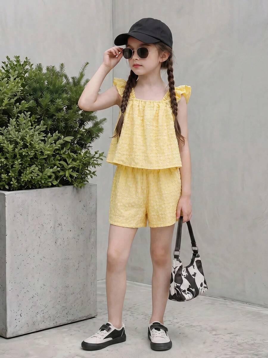 Tween girl wearing a blue and white striped sleeveless top featuring embroidery details and ruffle trim with matching shorts.