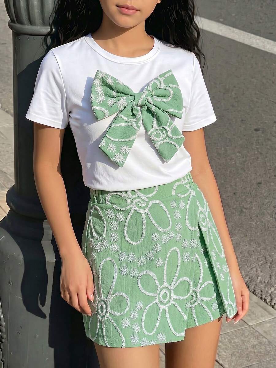 Tween girls 2-piece blue outfit featuring a short sleeve round neck t-shirt with a bow front detail and an asymmetric wrap skort.