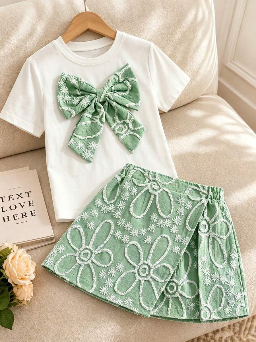 Tween girls 2-piece blue outfit featuring a short sleeve round neck t-shirt with a bow front detail and an asymmetric wrap skort.