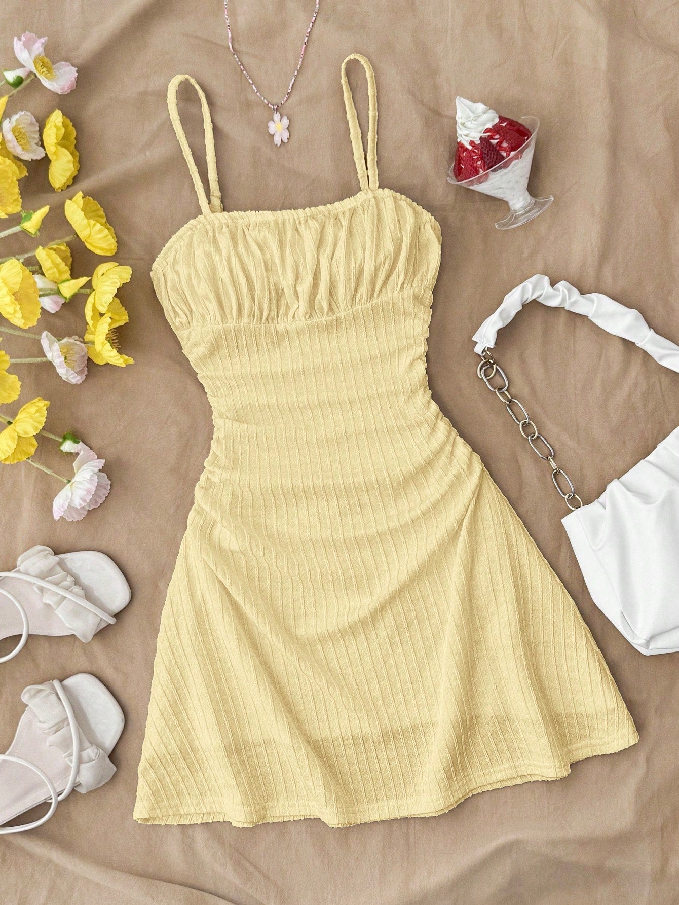 Tween girl yellow mini sundress with large pink floral hibiscus print, spaghetti straps, high waist, flared hem, and sleeveless cami style for summer beach wear