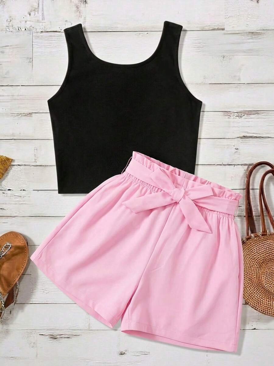 Tween girl wearing a casual 2-piece set featuring a black rib-knit scoop neck tank top and leopard print paperbag waist shorts with a matching belt.