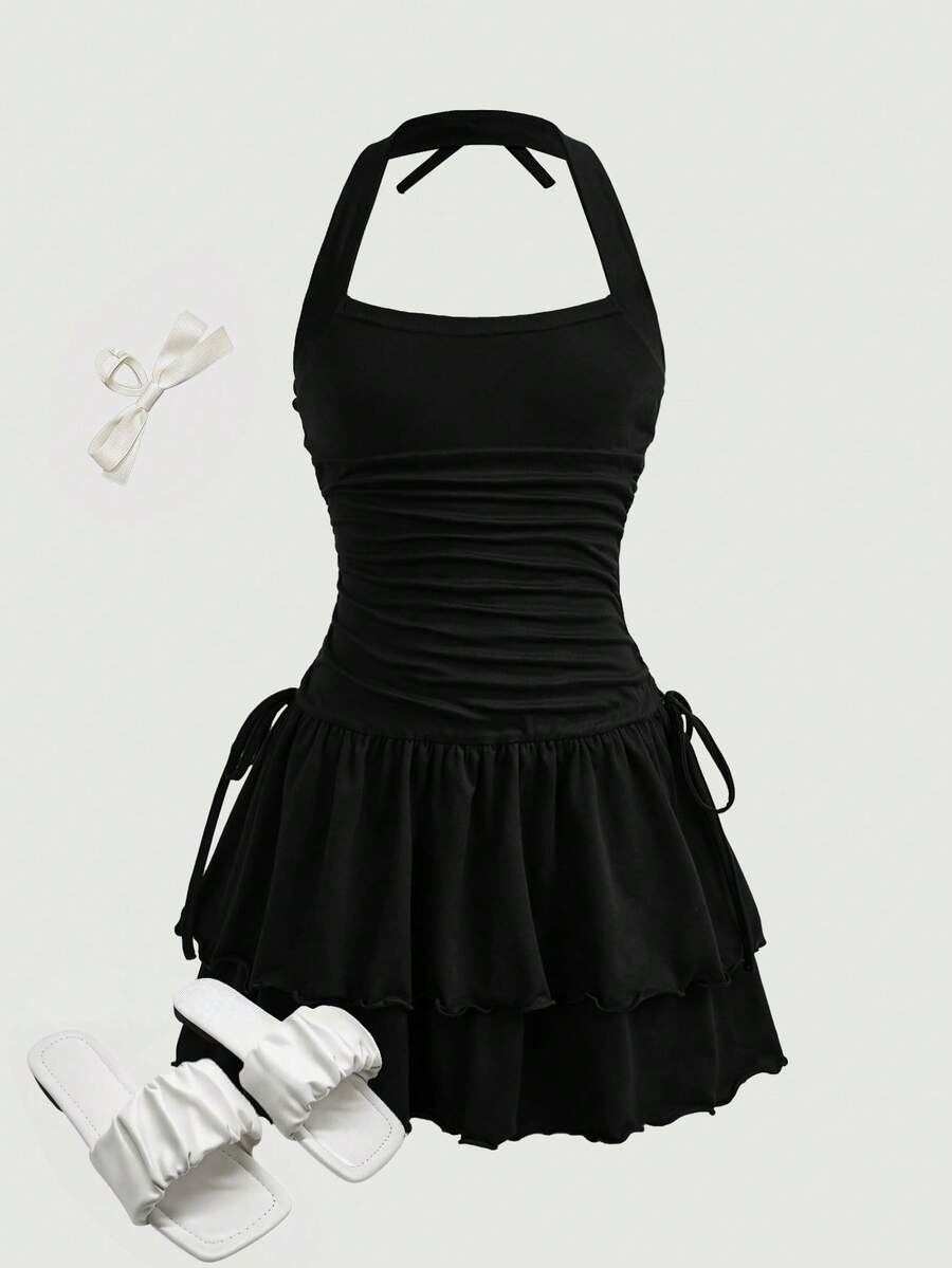 Black sleeveless halter polka dot mini dress for tween girls featuring a high waist and flared hem
