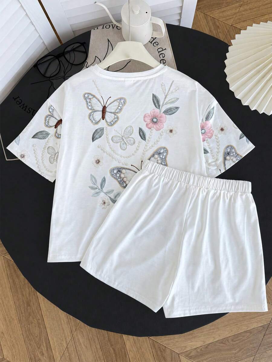 Tween girl wearing a black and white striped drop-shoulder crew neck t-shirt with bow embroidery paired with matching tie-waist shorts.