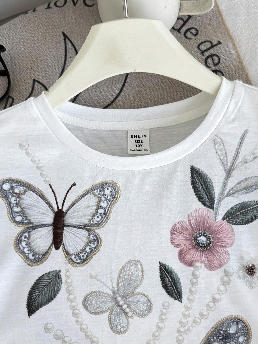 Tween girl wearing a black and white striped drop-shoulder crew neck t-shirt with bow embroidery paired with matching tie-waist shorts.