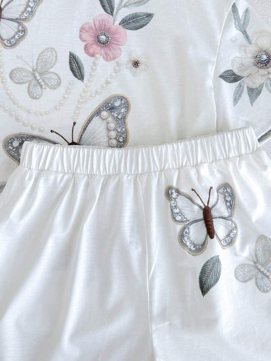 Tween girl wearing a black and white striped drop-shoulder crew neck t-shirt with bow embroidery paired with matching tie-waist shorts.
