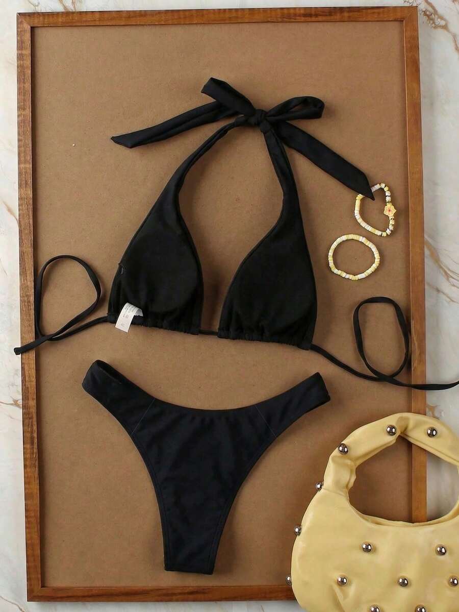 Women's halter neck bikini swimwear set featuring a wireless bra top with removable padding and mid waist bikini bottom.