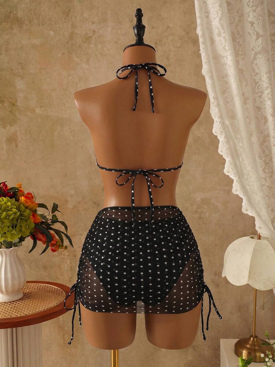 Women's black 3-piece bikini set featuring a halter triangle top with removable padding, high-waisted bottoms, and a knee-length mesh skirt with tie details.