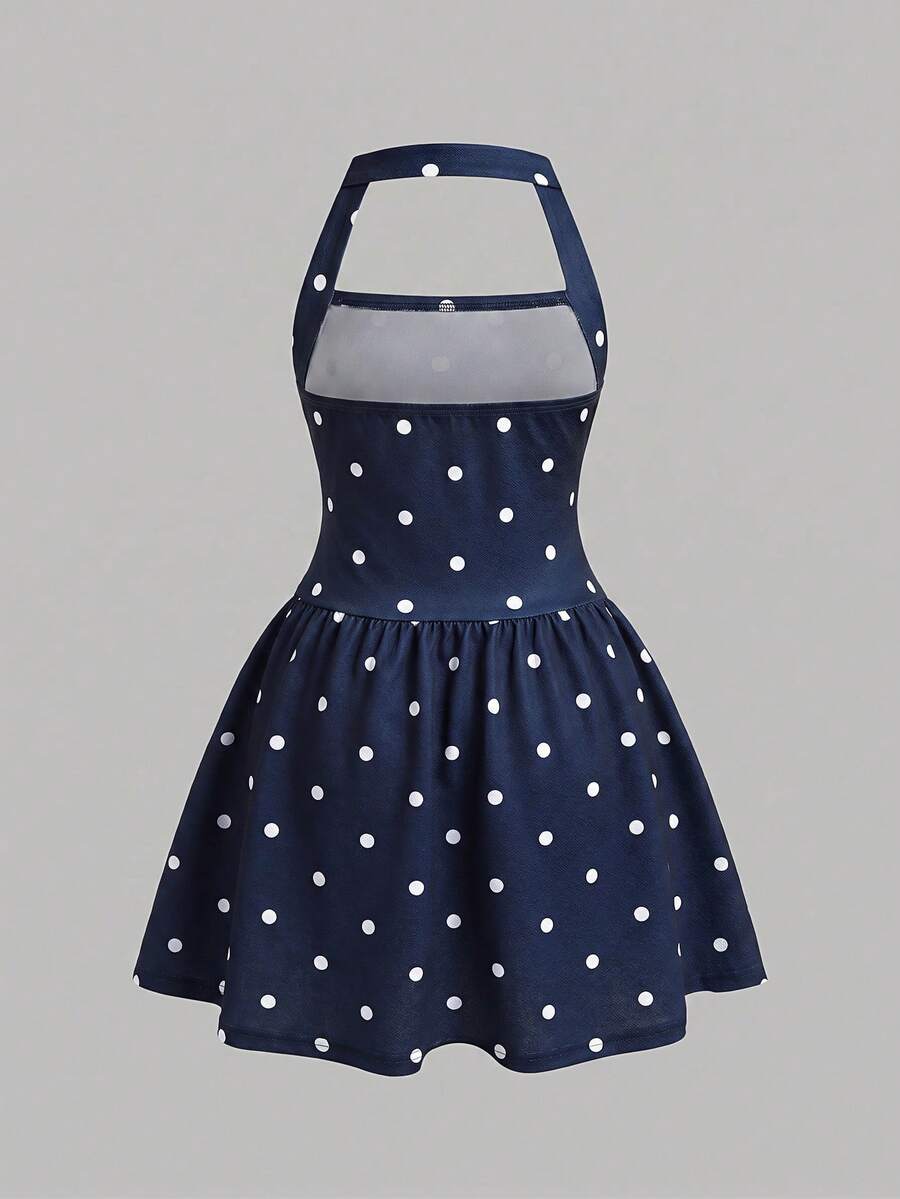 Black sleeveless halter polka dot mini dress for tween girls featuring a high waist and flared hem