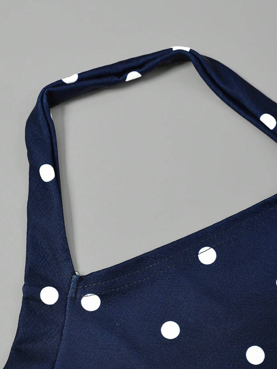 Black sleeveless halter polka dot mini dress for tween girls featuring a high waist and flared hem