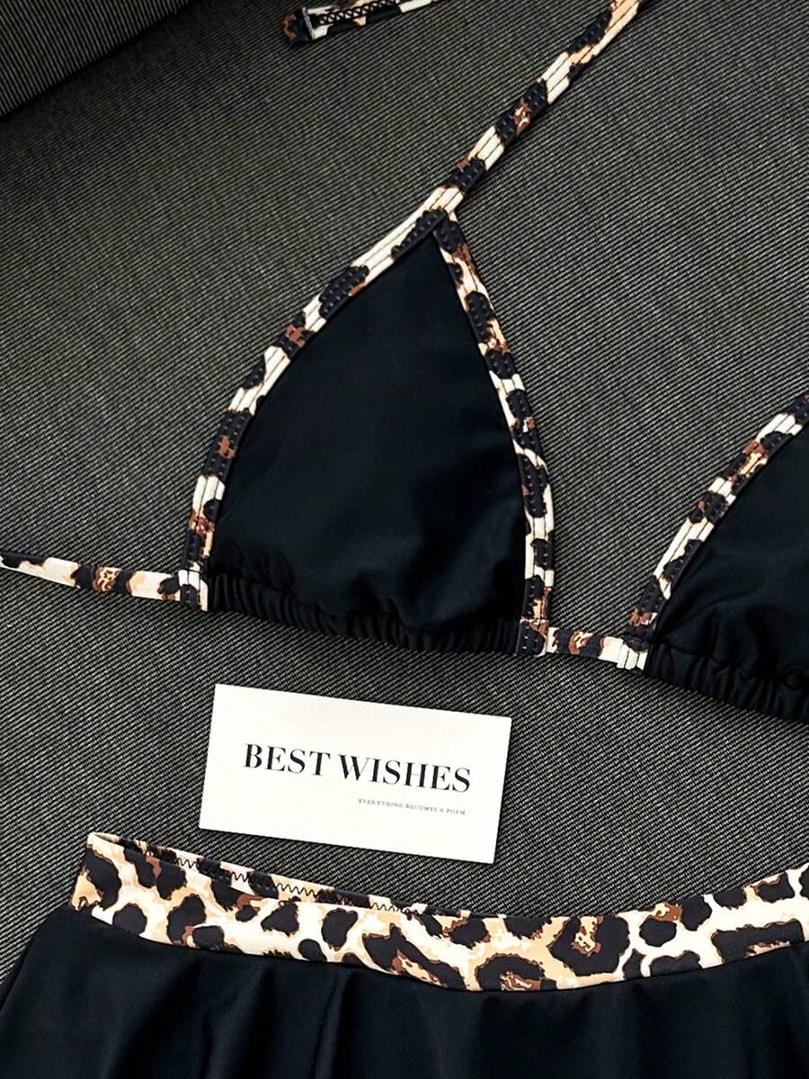 Women's 70s retro black and white polka dot bikini set featuring a halter triangle top and ultra low waist bottoms.