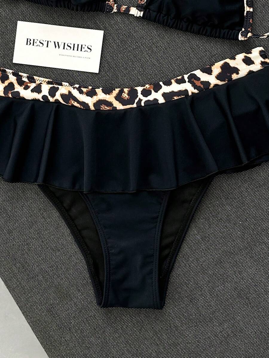 Women's 70s retro black and white polka dot bikini set featuring a halter triangle top and ultra low waist bottoms.