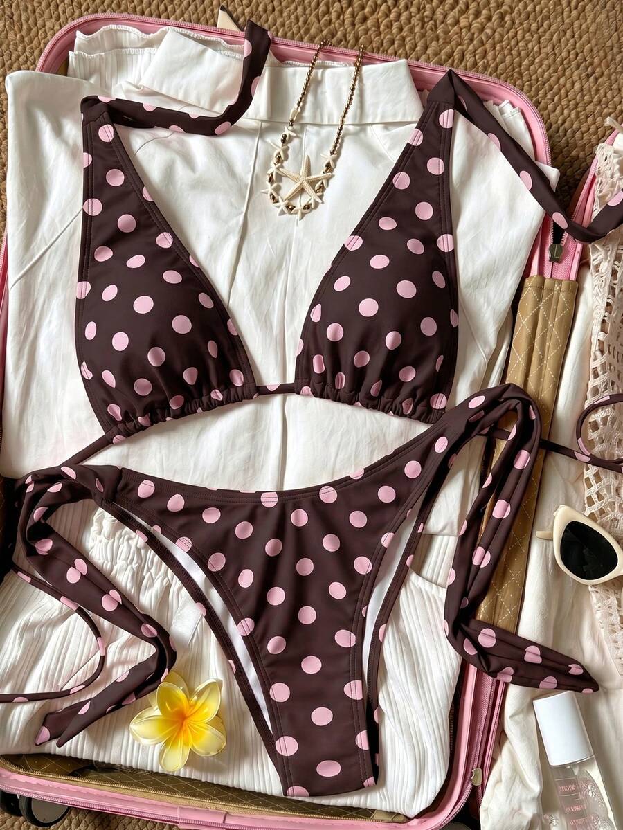Women's polka dot two-piece bikini set featuring a backless halter top with triangle cups and matching tie-side bottoms.