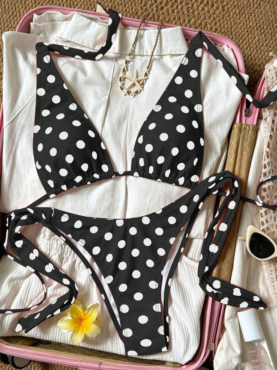 Women's polka dot two-piece bikini set featuring a backless halter top with triangle cups and matching tie-side bottoms.