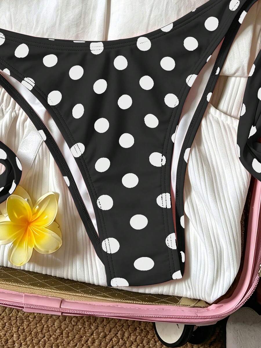 Women's polka dot two-piece bikini set featuring a backless halter top with triangle cups and matching tie-side bottoms.