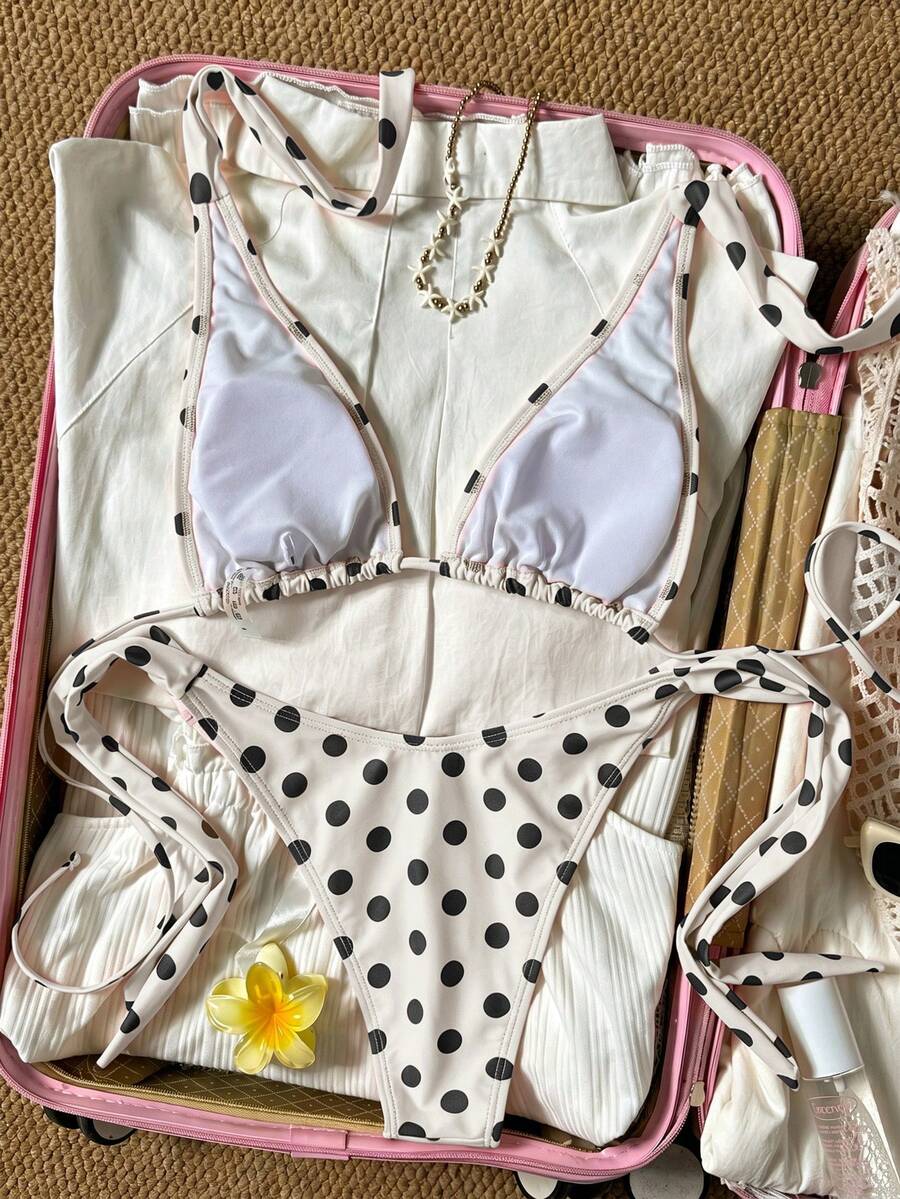 Women's polka dot two-piece bikini set featuring a backless halter top with triangle cups and matching tie-side bottoms.