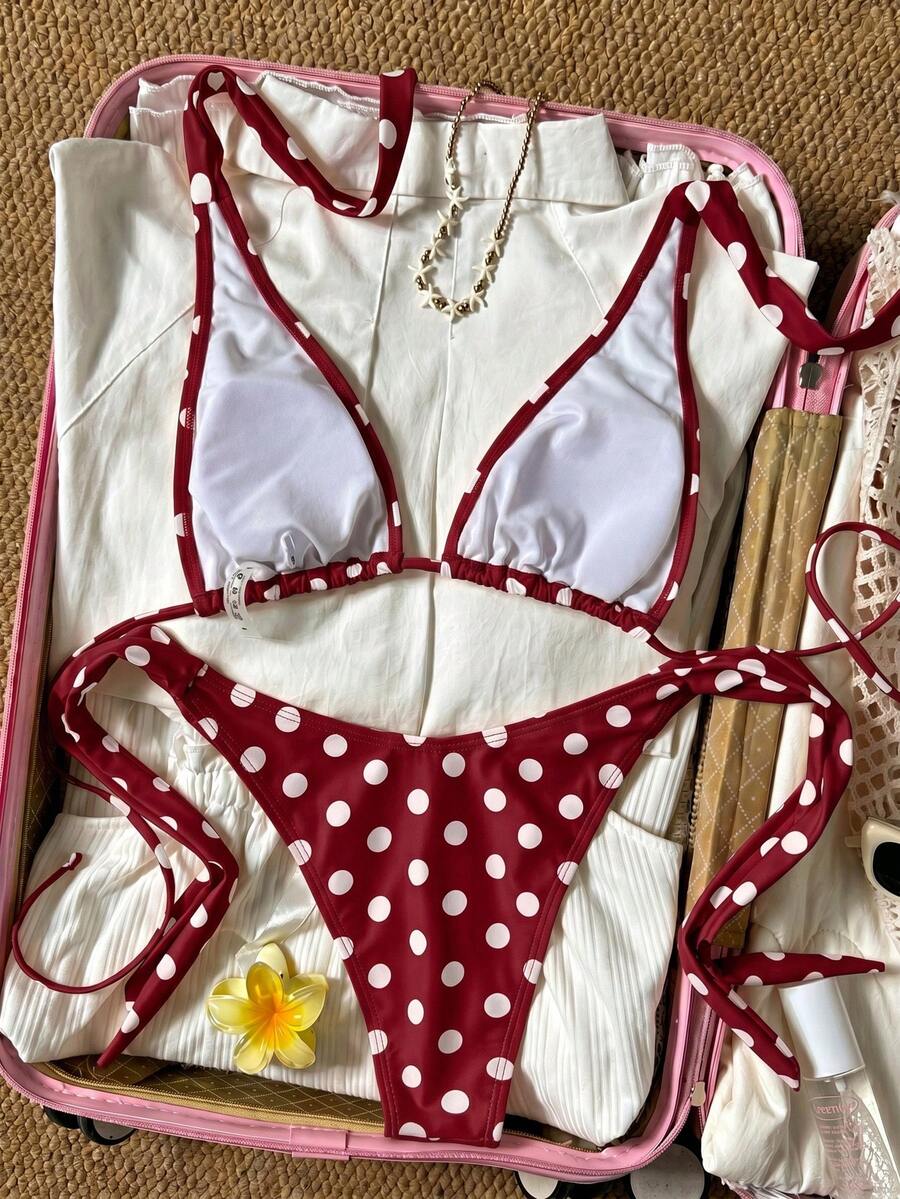 Women's polka dot two-piece bikini set featuring a backless halter top with triangle cups and matching tie-side bottoms.
