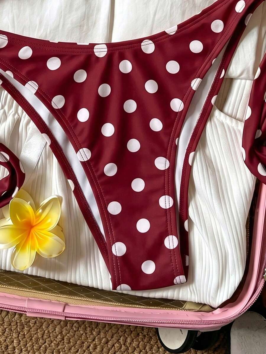 Women's polka dot two-piece bikini set featuring a backless halter top with triangle cups and matching tie-side bottoms.