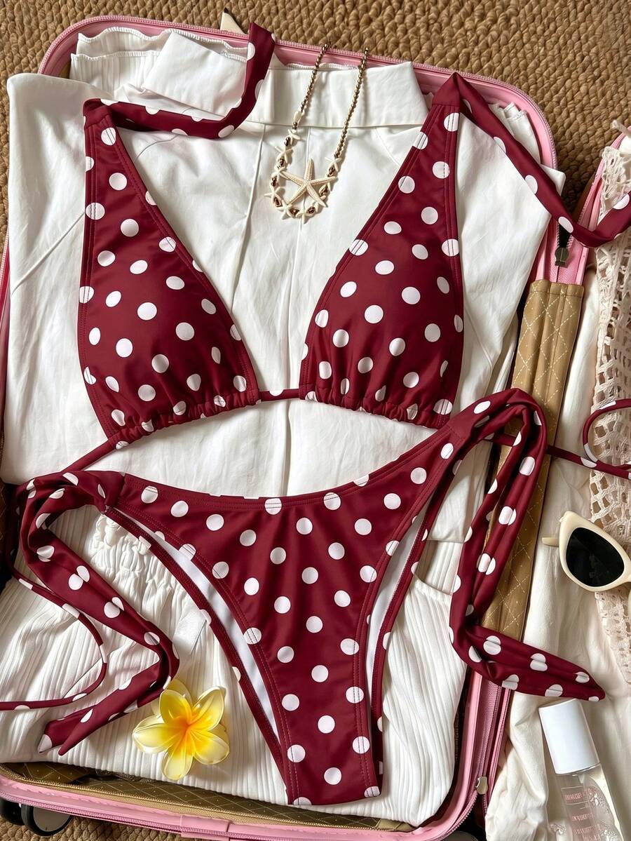Women's polka dot two-piece bikini set featuring a backless halter top with triangle cups and matching tie-side bottoms.
