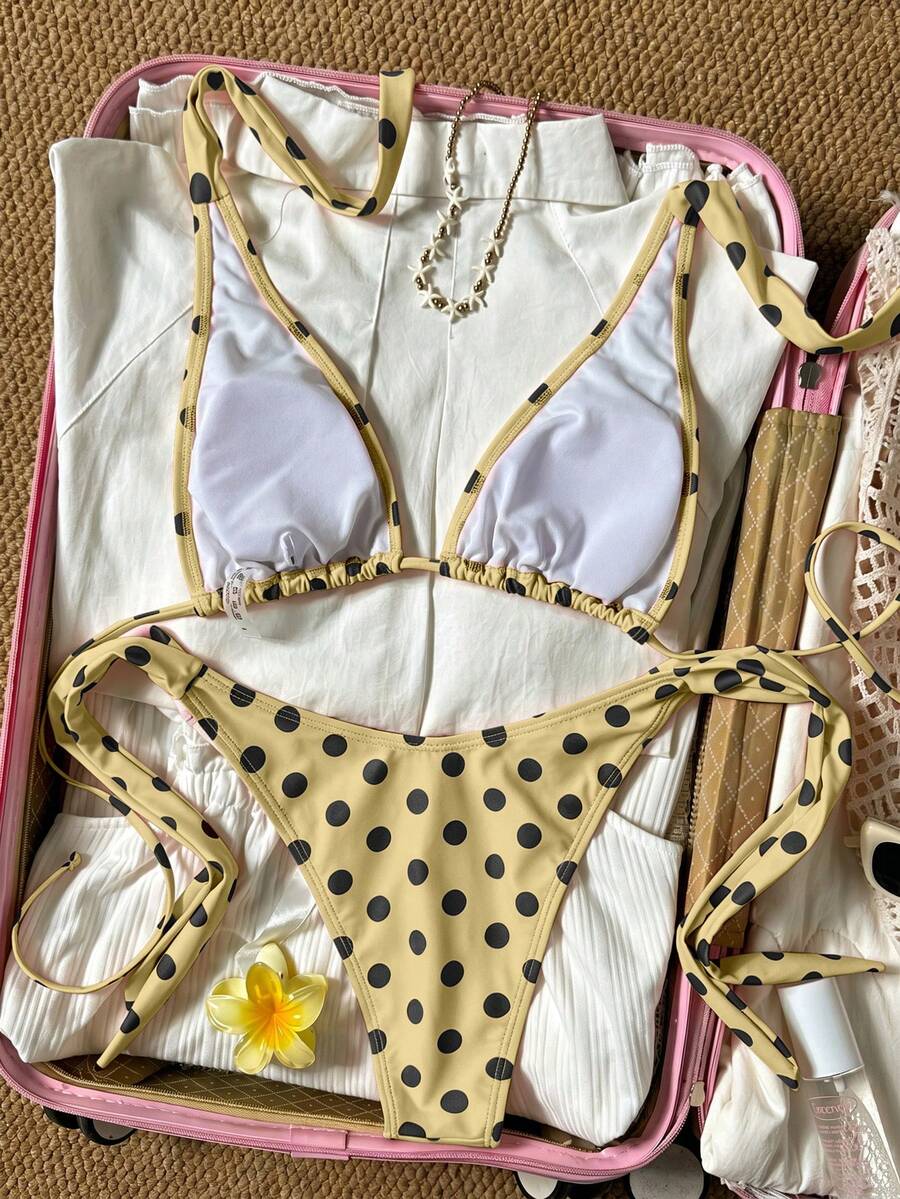 Women's polka dot two-piece bikini set featuring a backless halter top with triangle cups and matching tie-side bottoms.
