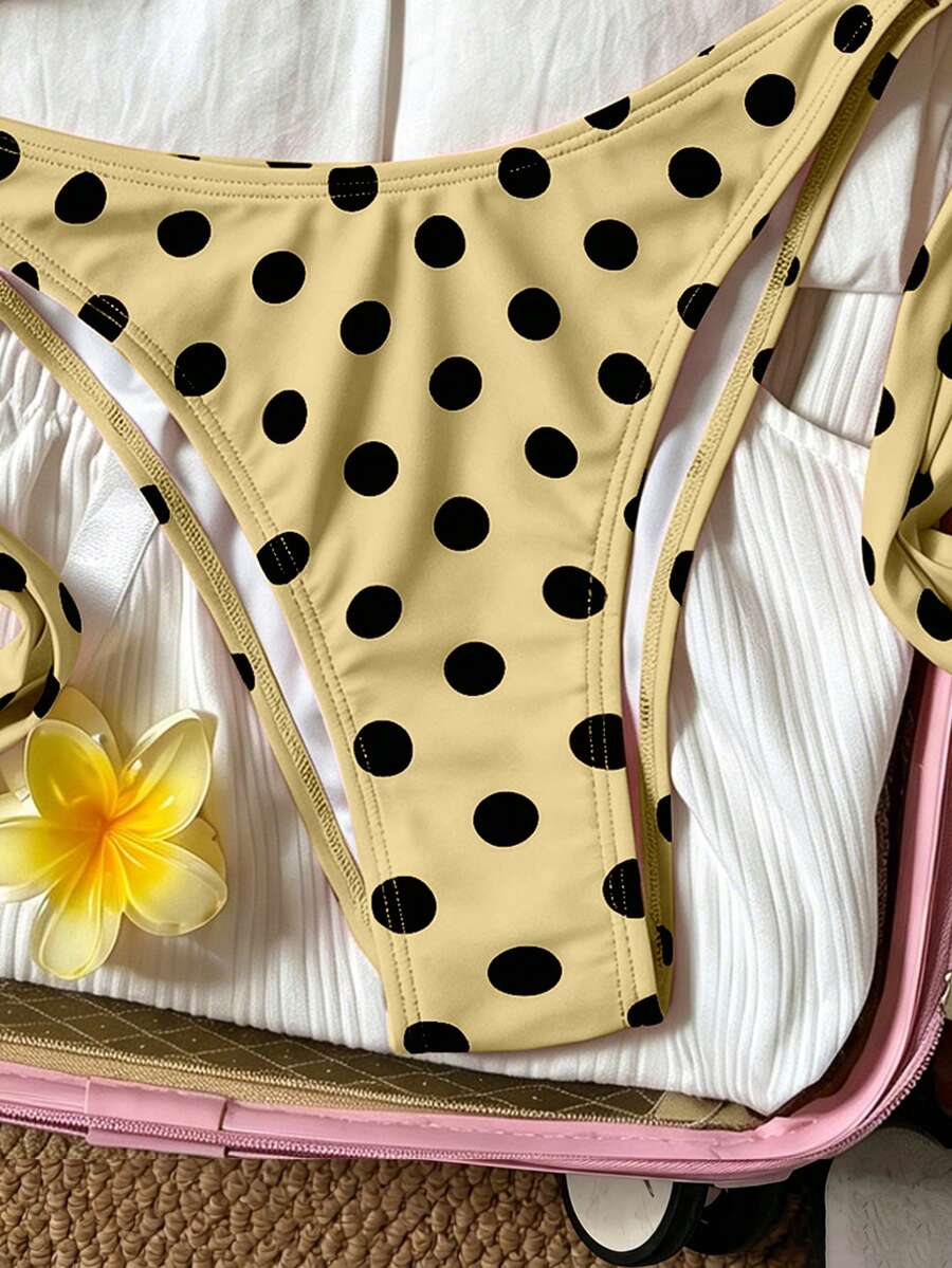 Women's polka dot two-piece bikini set featuring a backless halter top with triangle cups and matching tie-side bottoms.