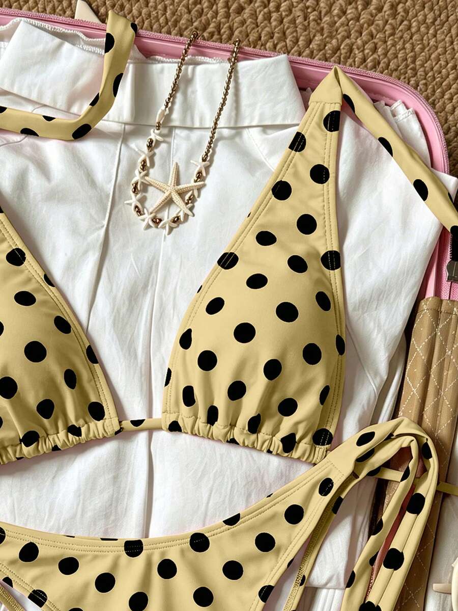 Women's polka dot two-piece bikini set featuring a backless halter top with triangle cups and matching tie-side bottoms.